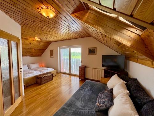 a living room with a couch and a tv and a bed at Dům Stašov in Stašov