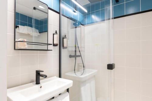 a white bathroom with a sink and a shower at Hotel Cantosorgue in L'Isle-sur-la-Sorgue