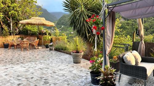 a patio with a table and chairs and flowers at maderedocevida in Boaventura