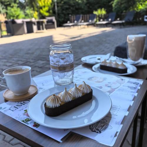 a table with plates of cupcakes and a glass of water at Chatičky Centrum Pastvinská přehrada in Nekoř