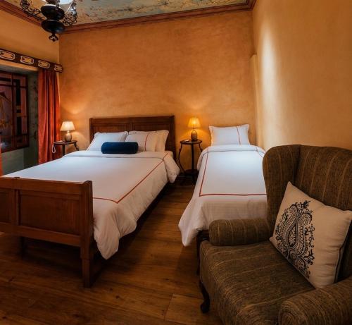 a hotel room with two beds and a couch at Hotel Ines Maria in Cuenca