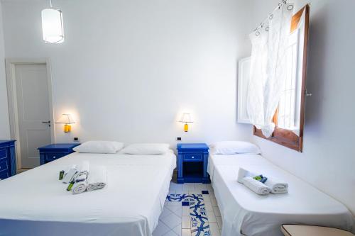 zwei Betten in einem Zimmer mit blau-weißen in der Unterkunft Il quadrifoglio home in Marettimo