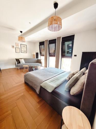 a bedroom with a large bed and a couch at Zs Apartment in Tuzla