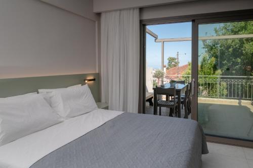 a bedroom with a bed and a balcony with a table at Blue Horizon luxury residence in Kanali