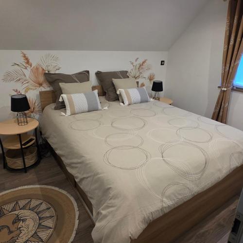 a large bed in a room with two tables at Gîte Vallée de Munster 3 étoiles chez Flavie & Ludo in Muhlbach-sur-Munster