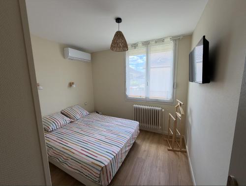 a small bedroom with a bed and a window at Meublé de Tourisme Le Swing in Marsannay-la-Côte