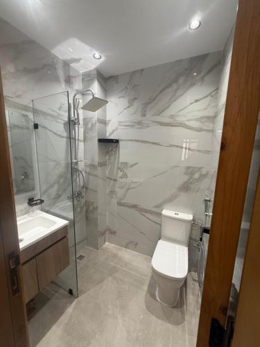 a bathroom with a toilet and a shower and a sink at اقامة هبة 6 in Yebha