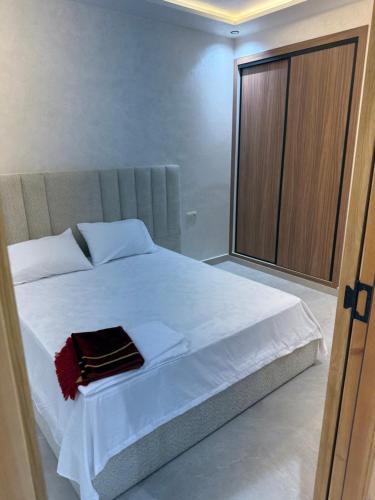 a bedroom with a white bed with a large window at اقامة هبة 6 in Yebha