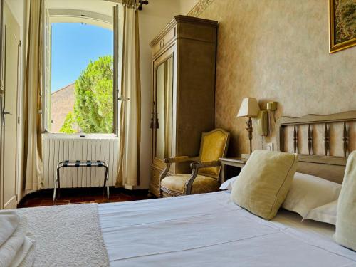 a bedroom with a large bed and a window at Hôtel Le Siècle in Mazan