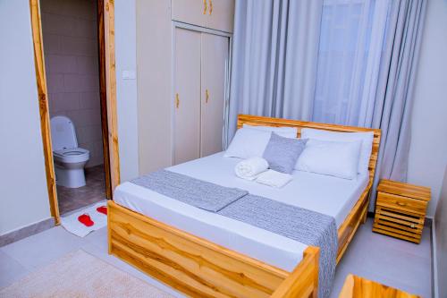 a bedroom with a bed and a bathroom with a toilet at ExtraMile Apartments - 2BR-R in Dodoma