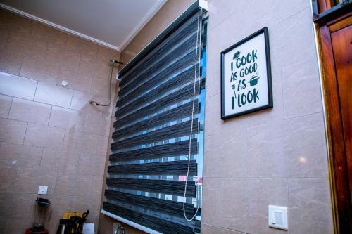 a bathroom with a window with black blinds at ExtraMile Apartments - 2BR-R in Dodoma