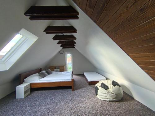 a bedroom with a bed and a vaulted ceiling at Domček u Alberta in Vrbov
