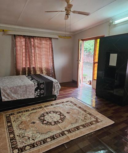 a bedroom with a bed and a television and a rug at Blessed home by the Mountain surrounded macadamia in Barberton