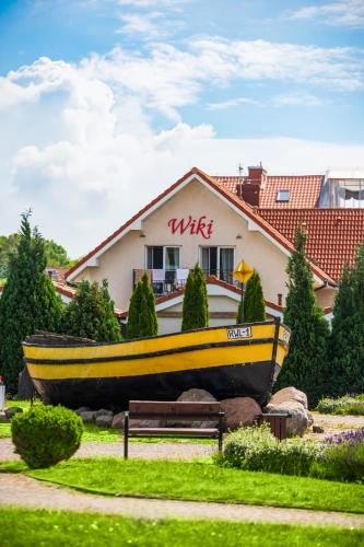 a yellow boat sitting in front of a house at Dom Gościnny Wiki in Rewal