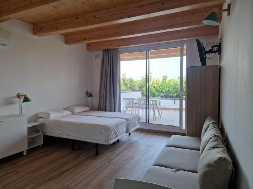 a bedroom with a bed and a couch and a balcony at Camping Clarà in Torredembarra