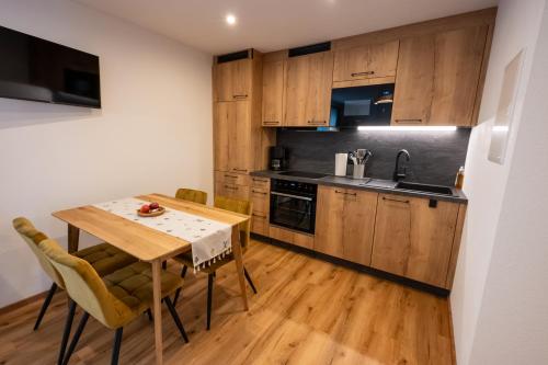 a kitchen with wooden cabinets and a table and chairs at Ferienwohnung Tiefengraber in Weiz