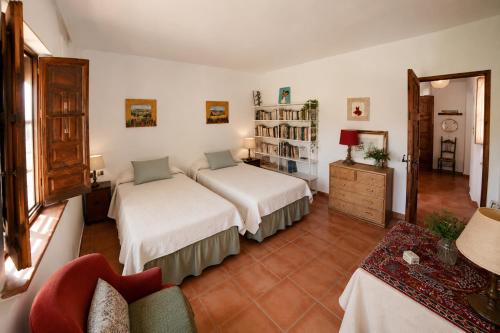 a bedroom with two beds and a living room at El Remanso de Marie in Órgiva