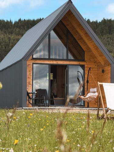 a small cabin with a large glass door in a field at Eternum Glamping in Žabljak