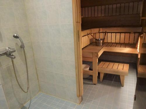 a bathroom with a shower and a table and a bench at Onnela in Saarijärvi