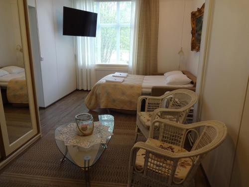 a hotel room with a bed and a table and chairs at Onnela in Saarijärvi
