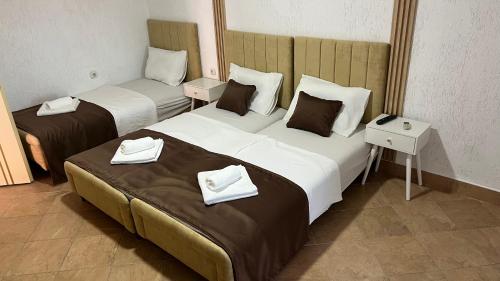 two beds in a hotel room with towels on them at Apartmani Tajra in Donji Štoj