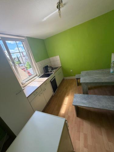 an empty kitchen with green walls and a window at Diezer Apartments II City in Diez