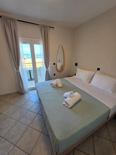a bedroom with a bed with towels on it at Magenta Beach in Porto Heli