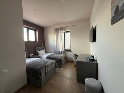 a hotel room with two beds and a desk at Lighthouse Hotel in Gyumri