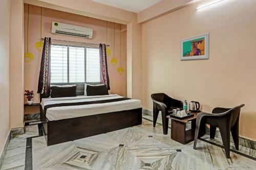 a bedroom with a bed and a table and chairs at Hotel O Aarshi Palace in Cuttack