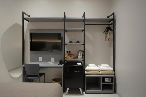 ein Zimmer mit einem Bett und einem Schreibtisch mit Computer in der Unterkunft Duna Queen Hotel Conceito in Barreirinhas