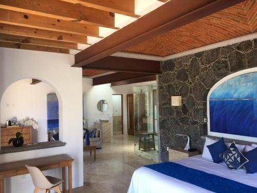a bedroom with a bed and a stone wall at Posada del Tepozteco - Hotel & Gallery in Tepoztlán