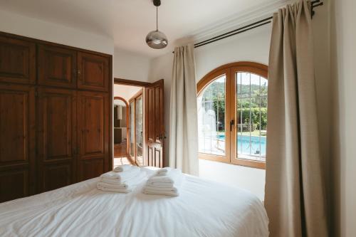 a bedroom with a white bed with towels on it at Villa Pony in Calonge