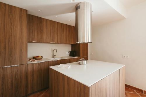 a kitchen with wooden cabinets and a white counter top at Villa Pony in Calonge