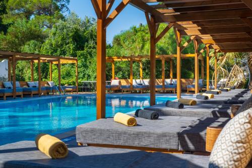 Eine Reihe von Liegestühlen neben einem Schwimmbecken in der Unterkunft Casa Trees Hotel in Ixia