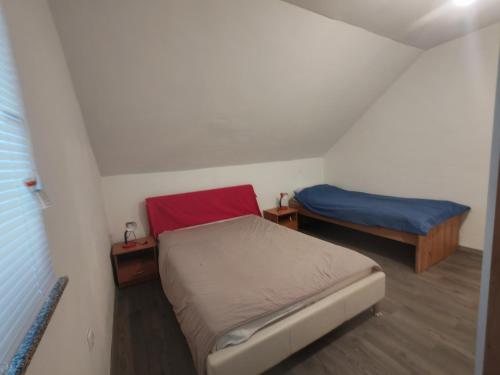 a small room with two beds in a attic at Apartmani Mila in Brlog