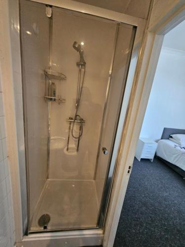 a shower with a glass door in a room at Dudley Port in Ocker Hill