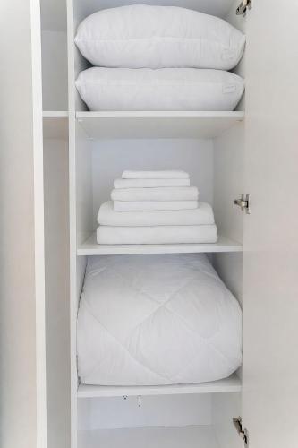 a white closet with white towels on shelves at Casa Bellamare Batumi in Batumi