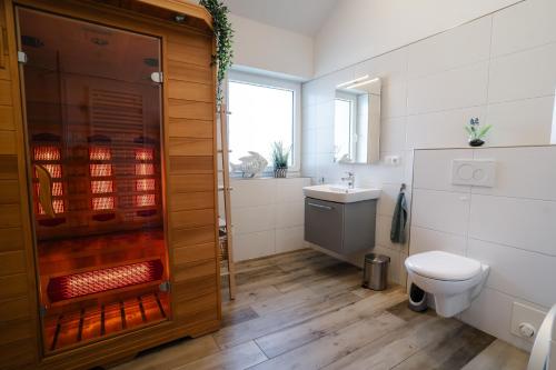 a bathroom with a toilet and a sink at Haus JADEHUUS in Schweiburg
