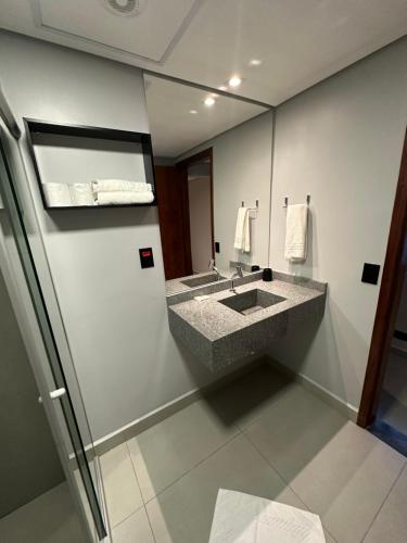 a bathroom with a granite sink and a mirror at Lito Palace Hotel in Registro