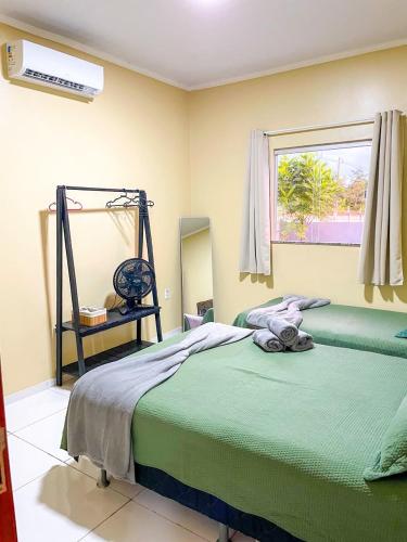 a bedroom with a green bed and a window at Casa em Condomínio, Jardim, Home Office in Castanhal