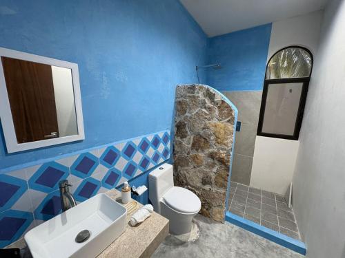 a blue bathroom with a toilet and a sink at Casa Laura Azul in El Cuyo