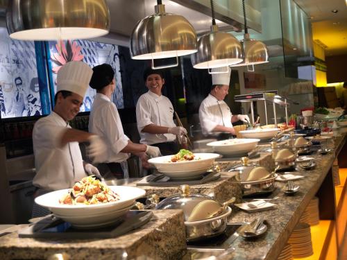 a group of chefs in a kitchen preparing food at Concorde Hotel Kuala Lumpur in Kuala Lumpur