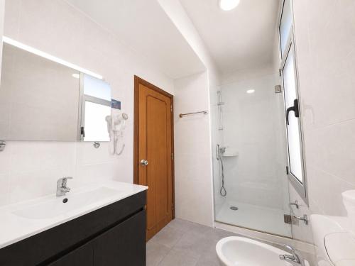 a white bathroom with a sink and a shower at Arcádia by Umbral in Fátima