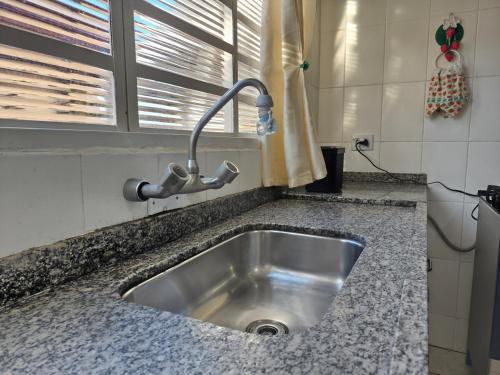 a kitchen sink with a faucet on a counter at Casa Lyrata in Tatuí