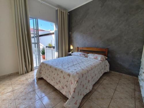a bedroom with a bed and a large window at Casa Lyrata in Tatuí