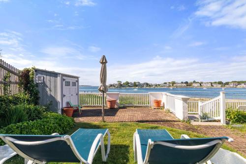 a patio with an umbrella and two chairs and an umbrella at Waterfront Private Beach Gorgeous Views in Yarmouth
