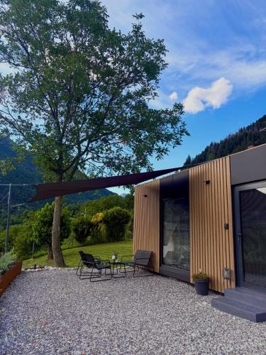 a building with a table and chairs next to a tree at Everest Experience in Paluzza