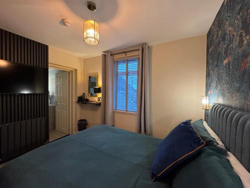 a bedroom with a bed and a large window at Tigh-Na-Mara Hotel in Sandhead