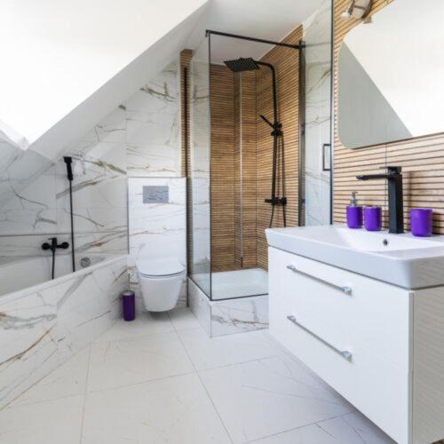 a bathroom with a sink and a shower and a toilet at Pensjonat Koral in Kołobrzeg