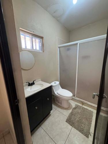 a bathroom with a toilet and a sink and a shower at Departamento #1 in San Carlos